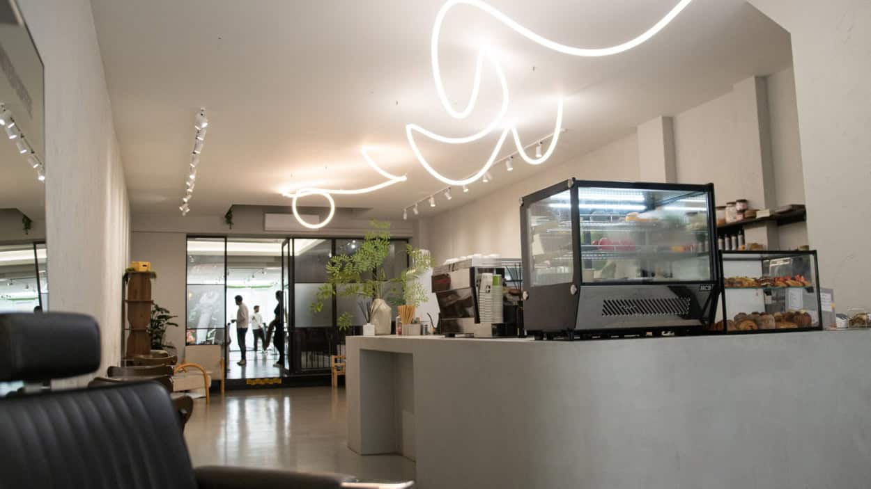 De koffiebar van United Coupes met vitrine en lichtkunst aan de wand