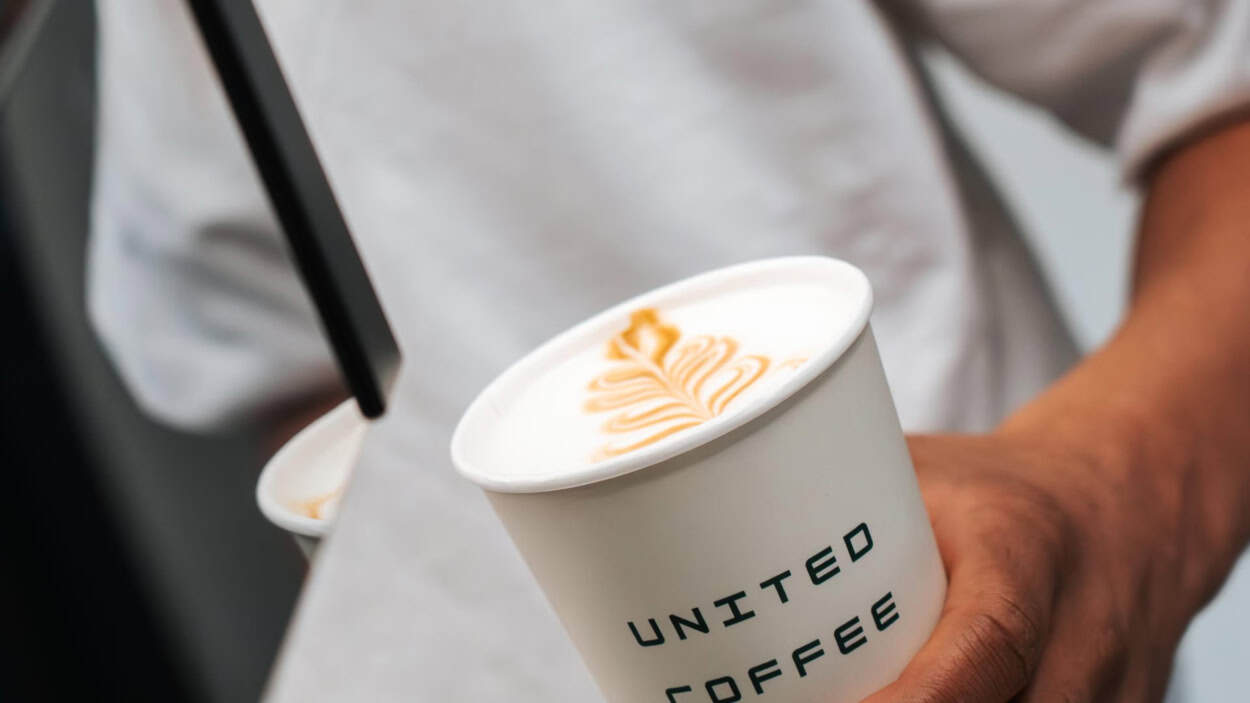Koffiebeker van United Coffee met latte art